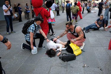 People attend injured pedestrians a moment after a car plunged into them in Times Square in New York on May 18, 2017.  A speeding car struck pedestrians in New York's Times Square on, killing one person and injuring 12 others in an accident in one of Manhattan's most popular tourists spots, officials said. / AFP PHOTO / Jewel SAMADJEWEL SAMAD/AFP/Getty Images