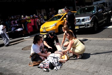 People and a police officer attend to an injured person moments after a car plunged into them in Times Square in New York on May 18, 2017.  A car plowed into a crowd of pedestrians in New York's bustling Times Square, leaving one person dead and at least 12 other injured in what officials said was an accident.  / AFP PHOTO / Jewel SAMADJEWEL SAMAD/AFP/Getty Images