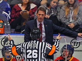 Coach Kris Knoblauch of the Erie Otters gets an explanation of a call from a referee during OHL action on Nov. 27, 2015 at the Hershey Centre in Mississauga, Ont.