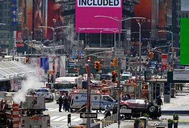 A smashed car, lower right, sits on the corner of Broadway and 45th Street in New York's Times Square after ploughing through a crowd of pedestrians at lunchtime on Thursday, May 18, 2017. Police do not suspect a link to terrorism and the driver was taken into custody to be tested for alcohol. (AP Photo/Seth Wenig)
