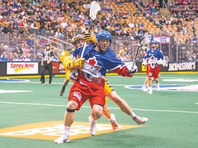 Tom Schreiber of the Toronto Rock tries to fend off pressure from a Georgia Swarm defender during Game 1 of the NLL East final last weekend at the ACC. The Rock needs a win in tonight’s rematch in Atlanta. (Ryan McCullough, photo)