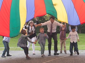 Prime Minister Justin Trudeau runs under a parachute with children during a visit to the Don Christian Recreation Centre in Surrey, B.C., on Friday May 19, 2017. THE CANADIAN PRESS/Darryl Dyck