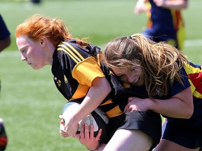 La Salle Black Knights’ Dakota Sharpe tries to get out of the grasp of a Napanee Golden Hawks player during the Kingston Area Secondary Schools Athletic Association girls rugby championship at Nixon Field on Thursday. Napanee won the game, 18-15, in penalty kicks after the teams were tied through overtime.