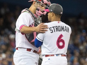 Jays catcher Luke Maile chats with Marcus Stroman during a game last week. (THE CANADIAN PRESS)