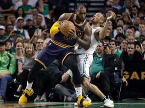 Cleveland Cavaliers forward LeBron James, left, muscles his way to the basket as Boston Celtics guard Avery Bradley, right, tries to defend during first half of Game 2 of the NBA basketball Eastern Conference finals, Friday, May 19, 2017, in Boston. (AP Photo/Elise Amendola)