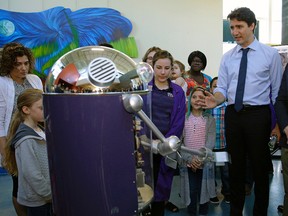 Prime Minister Justin Trudeau (right) talks to a robot at the Telus World of Science in Edmonton on Saturday May 20, 2017 where Trudeau met with families to bring attention to the Canada Child Benefit. (PHOTO BY LARRY WONG/POSTMEDIA)
