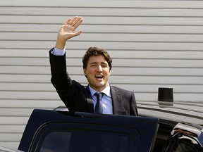 Prime Minister Justin Trudeau waves to protestors as he leaves the the Telus World of Science in Edmonton on Saturday May 20, 2017. Citizens were protesting the planned closing of the federal government's Case Processing Centre in Vegreville, Alberta. (PHOTO BY LARRY WONG/POSTMEDIA)