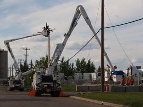 EPCOR workers make repairs to power poles that that were struck by a white Corvette which was allegedly stunting in the area of 121A Avenue and 160 Street, when it struck two poles. As a result, there are several power outages in the area on Saturday May 20, 2017, in Edmonton.   Greg  Southam / Postmedia