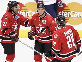 Team Canada’s Joe Sakic is congratulated by teammates Scott Niedermayer (left) and Robyn Regehr following his goal against Team Slovakia during the World Cup of Hockey Wednesday, Sept. 8, 2004 in Toronto. (THE CANADIAN PRESS/Adrian Wyld)