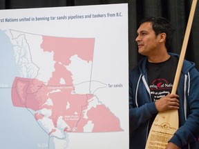 Actor Adam Beach holds an oar engraved with a declaration opposing a crude oil pipeline and tanker expansion as he stands by a map showing First Nations land and proposed pipelines during a signing ceremony in Vancouver, B.C., on December 1, 2011. Canadian actor Adam Beach finds himself walking a fine line after agreeing to be an ambassador for the federal government's Canada 150 celebrations. Beach, who overcame a troubled childhood on the Dog Creek reserve in Manitoba to star in Hollywood blockbusters such as "Flags of Our Fathers," feels he should help pay tribute to a government that has funded some of his films, as well as his film school for indigenous students in Winnipeg. But he also feels that in celebrating Canada, the mistreatment of indigenous people is often downplayed or ignored outright -- something he could help change. THE CANADIAN PRESS/Darryl Dyck