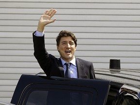 Prime Minister Justin Trudeau waves to protestors as he leaves the the Telus World of Science in Edmonton on Saturday May 20, 2017. Citizens were protesting the planned closing of the federal government's Case Processing Centre in Vegreville, Alta. (LARRY WONG/POSTMEDIA NETWORK)