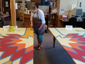Volunteer Judy Renner painting the barn quilt in the Clinton library last week. (Photo courtesy of Nancy deGans)