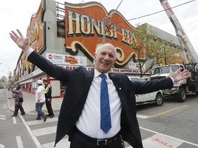 David Mirvish copies his father Ed Mirvish's popular pose from the 1980s when the Honest Ed's sign was installed. The iconic sign came down on Tuesday, May 23, 2017 and is expected to be moved to Ed Mirvish Theatre on Victoria St. (MICHAEL PEAKE/TORONTO SUN)