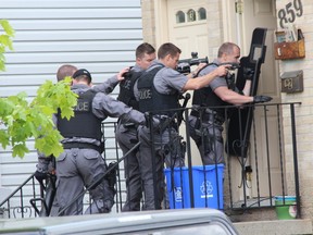 Tactical officers shout commands for a man to surrender at 859 Trafalgar St. Monday, May 22, 2017. (DALE CARRUTHERS, The London Free Press)