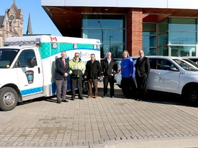Oxford Warden David Mayberry, paramedic Mike Maycock, Rural Green Energy representative Mark Shulman, Oxford County Paramedic Services Chief Ben Addley, county roads manager Melissa Abercrombie and Oxford CAO Peter Crockett (from left to right) stand with Oxford County's new environmentally friendly vehicles in front of the Oxford County administration building on Wednesday, March 8, 2015. (File photo)