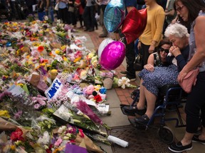 Women cry after placing flowers in a square in central Manchester on Wednesday, May 24, 2017, following a suicide attack at an Ariana Grande concert that left more than 20 people dead on Monday night. (AP/PHOTO)