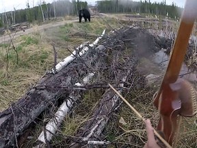 A black bear begins to stalk Richard Wesley of Hearst, Ont. (YouTube screen grab)