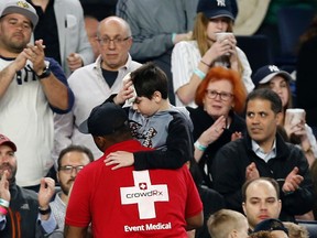 Fans applaud as a medical employee carries an injured youngster from the stands after the boy was hit in the head by a piece the Yankees's Chris Carter's bat that split during the seventh inning of a baseball game against the Kansas City Royals at Yankee Stadium in New York on May 24, 2017. (AP Photo/Kathy Willens)