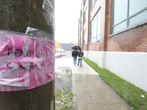 Fluorescent signs that say “Poop and scoop” remain on the hydro poles outside a building at 20 Leslie St. Earlier, someone posted several signs outside the building threatening to poison a large dog because their owner didn’t pick up their pet’s excrement on the lawn. (JACK BOLAND/TORONTO SUN)