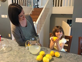 BRUCE BELL/THE INTELLIGENCER
Three-year-old Payton Carter and her mother Katie inspect the lemons they will use with the Cannifton girl opens her lemonade stand in Wellington on Saturday morning. She is trying to raise funds for the  Children’s Treatment Centre Playground Project at Belleville General Hospital where her brother Landon receives treatment.