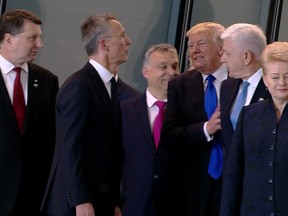 In this image taken from NATO TV, Montenegro Prime Minister Dusko Markovic, second right, appears to be pushed by U.S. President Donald Trump as they were given a tour of NATO's new headquarters after taking part in a group photo, during a NATO summit of heads of state and government in Brussels on Thursday, May 25, 2017. (NATO TV via AP)