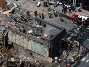 In this June 5, 2013 file photo rescue personnel search the scene of a building collapse in downtown Philadelphia. An arbitrator has awarded $95.6 million to a Ukrainian immigrant who was seriously injured in a 2013 Philadelphia building collapse. Mariya Plekan's attorney, Andrew Stern, announced the division of the $227 million settlement on Thursday, May 25, 2017. (AP Photo/Jacqueline Larma, File)