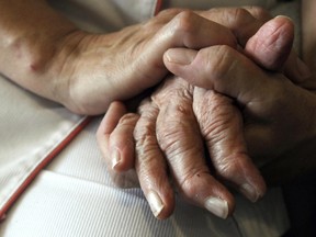 A nurse holds the hands of a person suffering from Alzheimer's disease on September 21, 2009 at Les Fontaines retirement home in Lutterbach , eastern France. (SEBASTIEN BOZON/AFP/Getty Images)