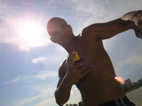 Marcel Escobar applies suntan oil August 28, 2001 at Miami Beach, Florida. (Photo by Joe Raedle/Getty Images)