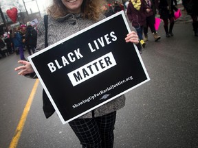 A woman holds a Black Lives Matter sign while marching in Ottawa January 21, 2017. Ashley Fraser/Postmedia