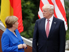 German Chancellor Angela Merkel, left, speaks with U.S. President Donald Trump during a group photo at the G7 Summit in the Ancient Theatre of Taormina ( 3rd century BC) in the Sicilian citadel of Taormina, Italy, Friday, May 26, 2017. Leaders of the G7 meet Friday and Saturday, including newcomers Emmanuel Macron of France and Theresa May of Britain in an effort to forge a new dynamic after a year of global political turmoil amid a rise in nationalism. (AP Photo/Andrew Medichini)