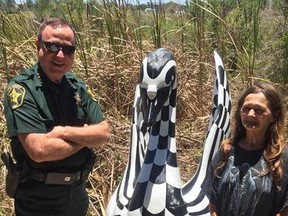 Polk County Sheriff Grady Judd (left) poses beside the found swan statue with  (Polk County Sheriff's Office/Facebook)