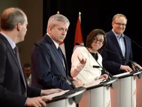 Niki Ashton speaks with Guy Caron as Charlie Angus and Peter Julian listen during the first debate of the federal NDP leadership race, in Ottawa on March 12, 2017. Justin Tang/The Canadian Press