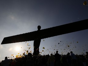 People attend a service at the Angel of the North in Gateshead, England, in memory of Manchester bombing victims Courtney Boyle and stepfather Philip Tron, Friday, May 26, 2017. Hundreds gathered at the landmark in their home town of Gateshead for a balloon release. Miss Boyle, a 19-year-old student at Leeds Beckett University, and Mr Tron, 32, were picking up her sister from the concert when they were killed. Owen Humphreys/PA via AP