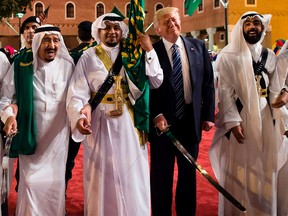 A handout picture provided by the Saudi Royal Palace on May 20, 2017, shows U.S. President Donald Trump (second from right) and Saudi Arabia's King Salman bin Abdulaziz al-Saud (left) dancing with swords at a welcome ceremony ahead of a banquet at the Murabba Palace in Riyadh. (AFP PHOTO/SAUDI ROYAL PALACE/BANDAR AL-JALOUD)