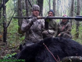 The Alberta government says an online video showing a black bear being killed by a spear is unacceptable and it plans to ban the practice. American Josh Bowmar, seen here at left in a still image made from video, displays the spear with which he killed a large black bear, which resulted in a public backlash.