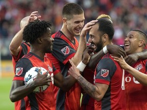 Toronto FC’s Victor Vazquez (centre right) is mobbed by teammates after scoring his second goal and his team’s third against the Columbus Crew at BMO Field last night. (Chris Young/The Canadian Press)