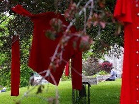 Red dresses festoon the trees surrounding St. Thomas' Anglican Church on Friday May 26, 2017 in Belleville, Ont. The dresses are a memorial to the more than a thousand missing and murdered Aboriginal women in Canada. Tim Miller/Belleville Intelligencer/Postmedia Network