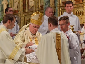 Ottawa Archbishop Terrence Prendergast takes part in the ordination of a priest.