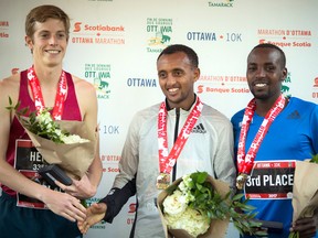 Ottawa 10K men’s winner Leul Gebresilase celebrates with second-place Martin Hehir and bronze winner Nicholas Bor. Ashley Fraser/Postmedia Network
