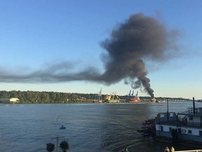 Smoke from a fire at a recycling plant in Delta, B.C., is seen over the Fraser River.  (Alice Cavanagh/Twitter)