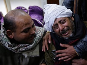 In this Monday, Feb. 16, 2015 file photo, a man is comforted by others as he mourns over Egyptian Coptic Christians who were captured in Libya and killed by militants affiliated with the Islamic State group, outside of the Virgin Mary church in the village of el-Aour, near Minya, 220 kilometers (135 miles) south of Cairo, Egypt. (AP Photo/Hassan Ammar, File)