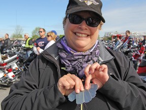 Colleen Oomen holds tags representing the five people who inspire her to participate in the Ride for Dad, hosted at CFB Kingston on Saturday. (Steph Crosier/The Whig-Standard)