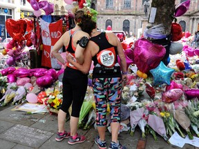 Marathon runners pay respect at flower tributes in St Ann's square, before the Great Manchester Run in Manchester, England Sunday, May 28, 2017. More than 20 people were killed in an explosion following a Ariana Grande concert at the Manchester Arena late Monday evening. (AP Photo/Rui Vieira)