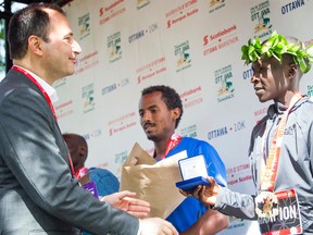 Eliud Kiptanui receives his award as the top finisher in the marathon yesterday as part of at the Tamarack Ottawa Race Weekend. (ASHLEY FRASER/Postmedia Network)