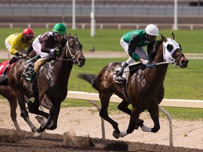 Keishan Balgobin (left) riding Trooper John chases Shannon Beauregard on Bar No Q (left) and Rico Walcott on Rock Victor to a win during the Western Canada Handicap at Northlands Park in Edmonton, Alta. on Saturday, May 27, 2017.