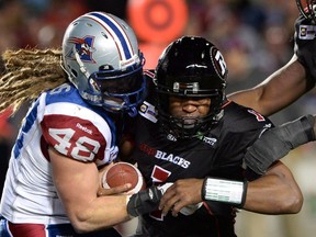 Ottawa Redblacks' Henry Burris is sacked by Montreal Alouettes' Bear Woods during CFL action in Ottawa on Friday, Oct. 24, 2014. The Alouettes have released all-star linebacker Woods.The 30-year-old was named the CFL East Division player of the year for the second time in his career last season. THE CANADIAN PRESS/Sean Kilpatrick