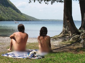 In this Thursday, May 18, 2017 photo, Michael Zarnowski, left, and Katelyn Comeau, of Thornton, N.H., relax at the clothing-optional beach known as the Southwest Cove of Lake Willoughby in Westmore, Vt. Located on state land, state officials said the area, which also includes hiking trails, gets so much use in the summer that upgrades need to be made to protect the area from over use. Beach users are opposed to the plan because they think it could threaten their ability to use the area. (AP Photo/Wilson Ring)