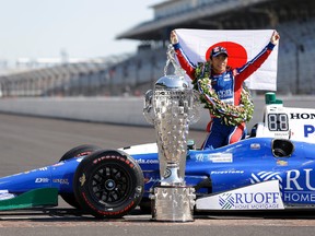 Indianapolis 500 champion Takuma Sato poses with the Borg-Warner Trophy during the traditional winners photo session on the start/finish line at the Indianapolis Motor Speedway in Indianapolis on May 29, 2017. (AP Photo/Michael Conroy)