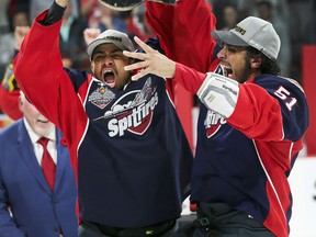 Windsor Spitfires Jeremiah Addison, left, and Jalen Chatfield raise the trophy after defeating the Erie Otters to win the Memorial Cup in Windsor, ON., on Sunday, May 28, 2017 May 28, 2017, at the WFCU Centre in Windsor, ON after defeating the Erie Otters. (DAN JANISSE/The Windsor Star)  Memorial Cup