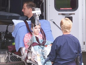 Ian McDonald, one of the many Walkerton children left seriously ill by the tainted water crisis of May 2000, is loaded onto an ambulance to be transferred to a London hospital in this image from the disaster.  (Free Press file photo )